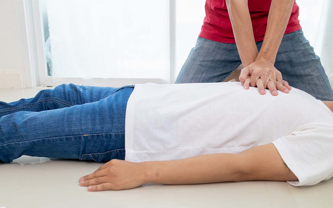 homem a fazer massagem cardíaca a outro homem, suporte básico de vida
