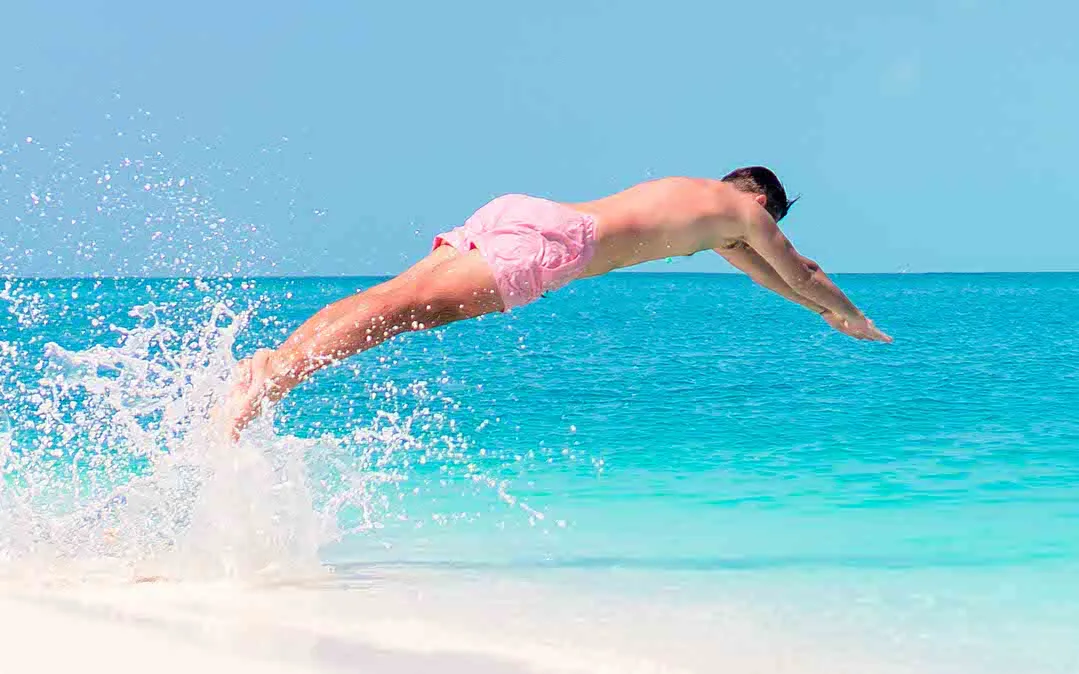 homem a mergulhar no oceano no verão em águas rasas